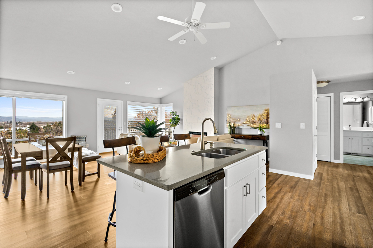 Photo of a kitchen with an island and dining room in a Rogue Valley Manor residence.